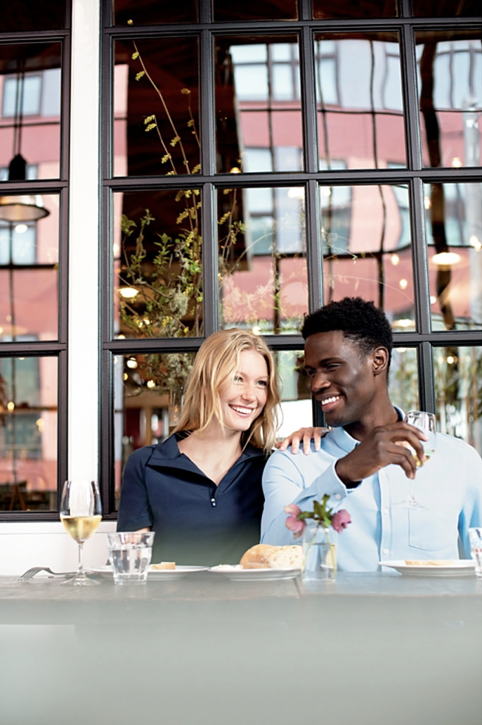 Man at a cafe with a friend wearing Advantage Tri-Blend Pique Long Sleeve Knitted Mens Button Down