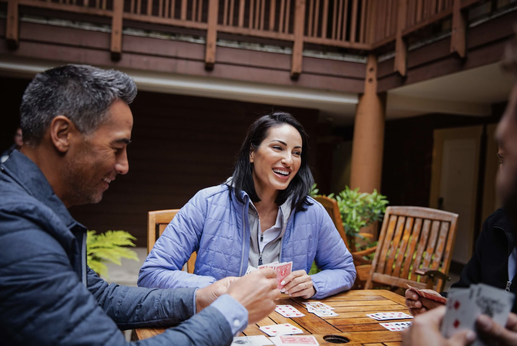 Friends playing a card game wearing cutter and buck outerwear