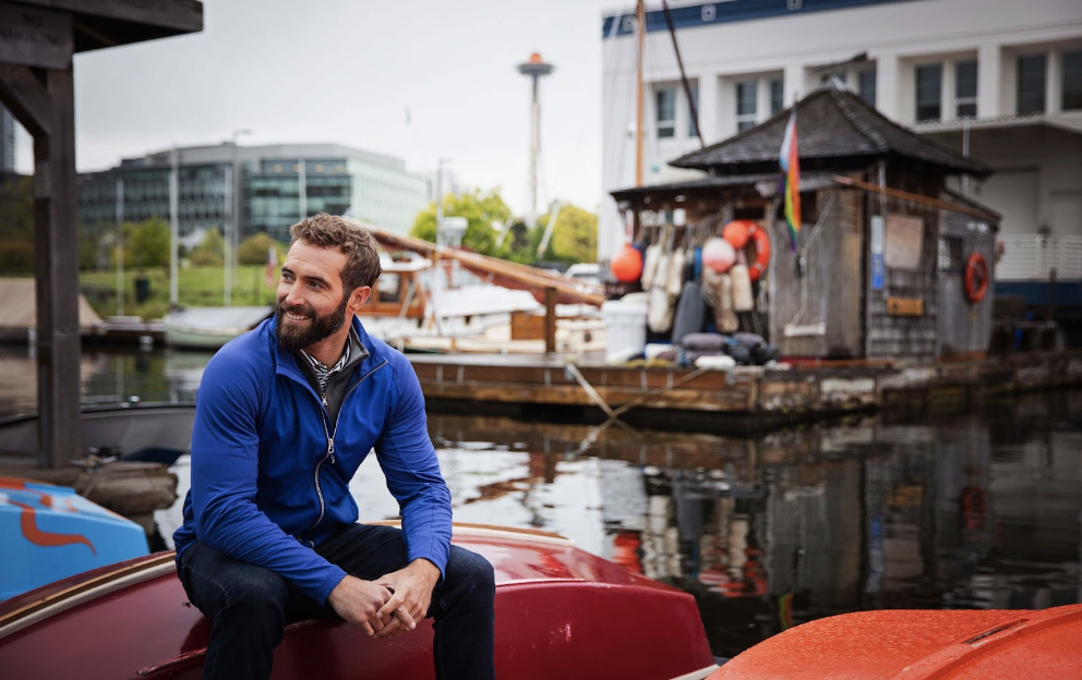 Man sitting on boat wearing Cutter & Buck Adapt Eco Knit Hybrid Recycled Mens Full Zip Jacket