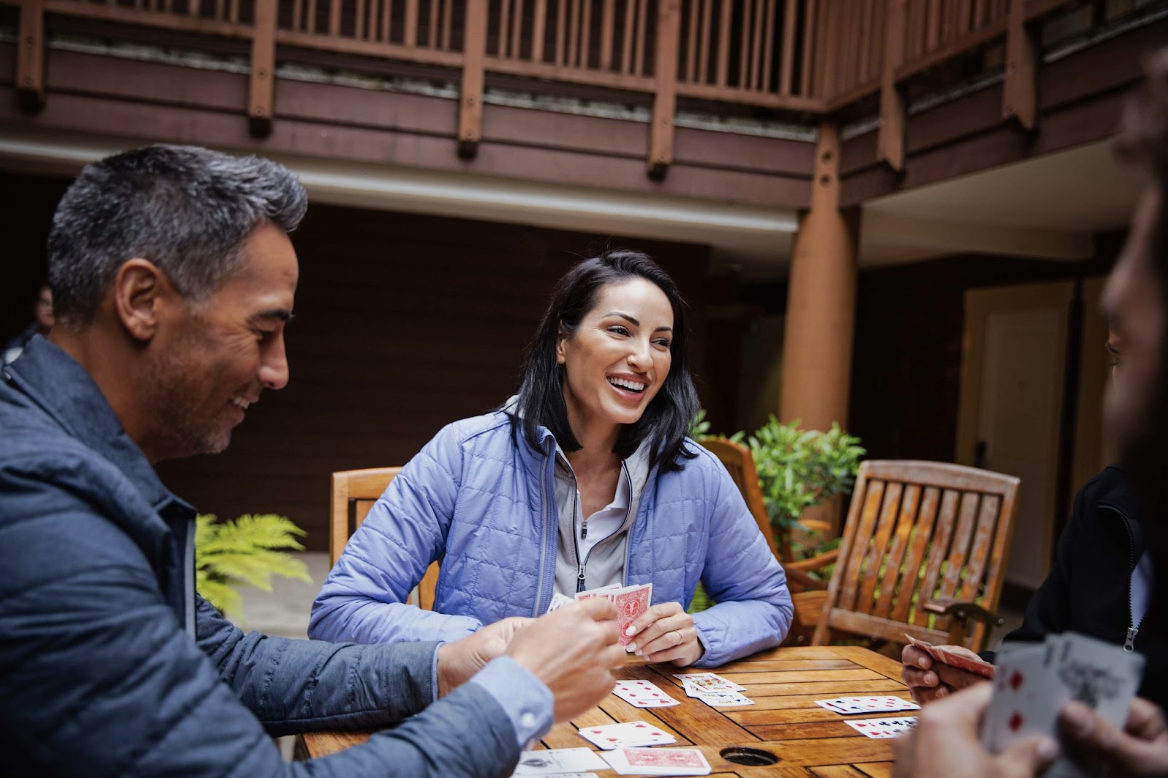 group of friends playing cards wearing cutter and buck jackets