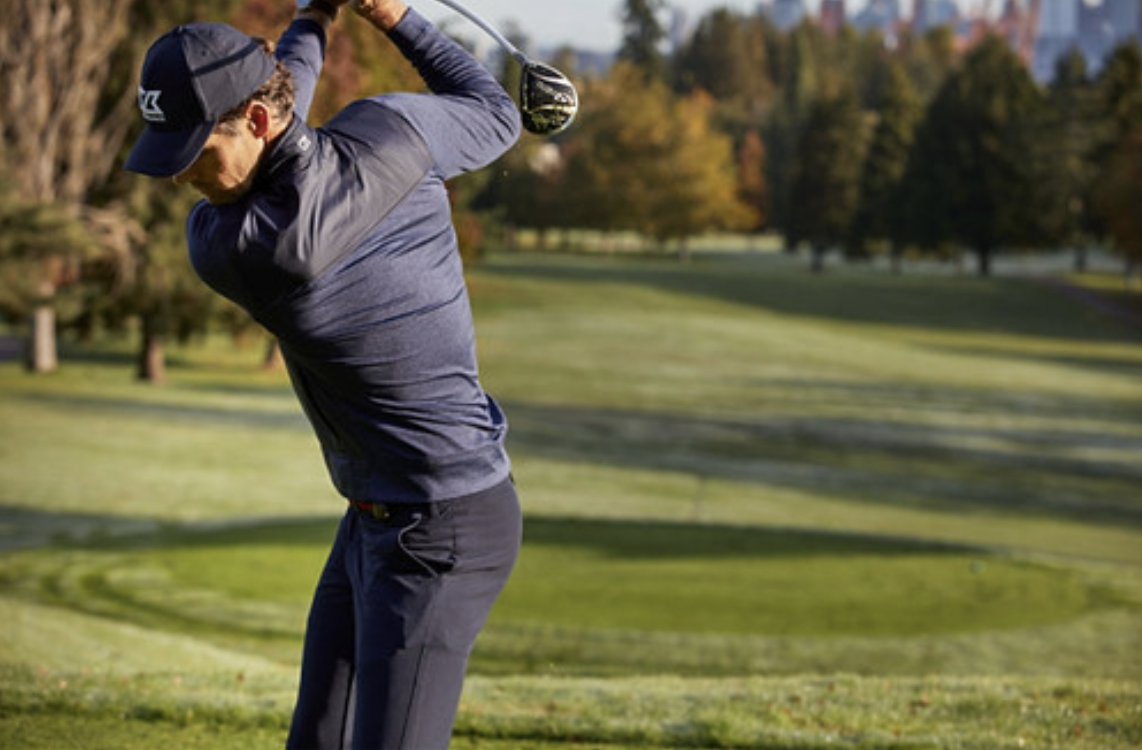 man playing golf wearing a jacket