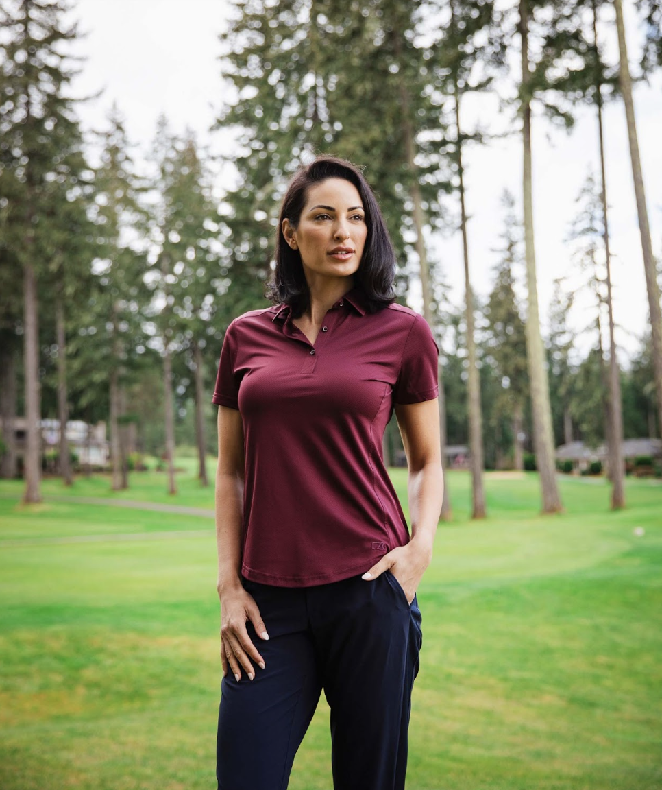 woman on golf course wearing golf polo