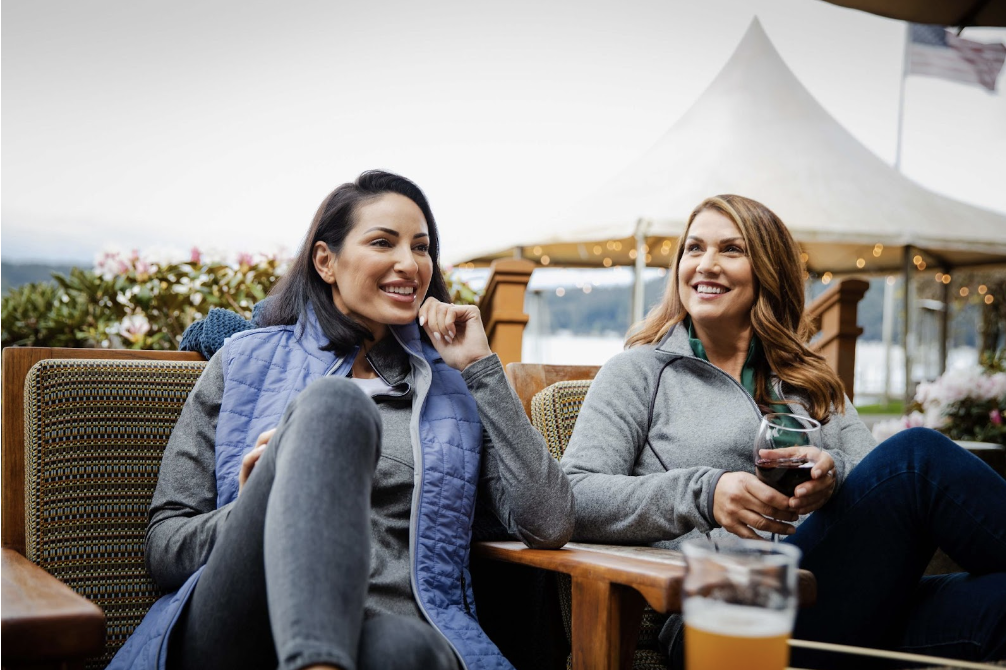 two women sitting outside talking